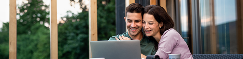 Man en vrouw glimlachend voor hun computer